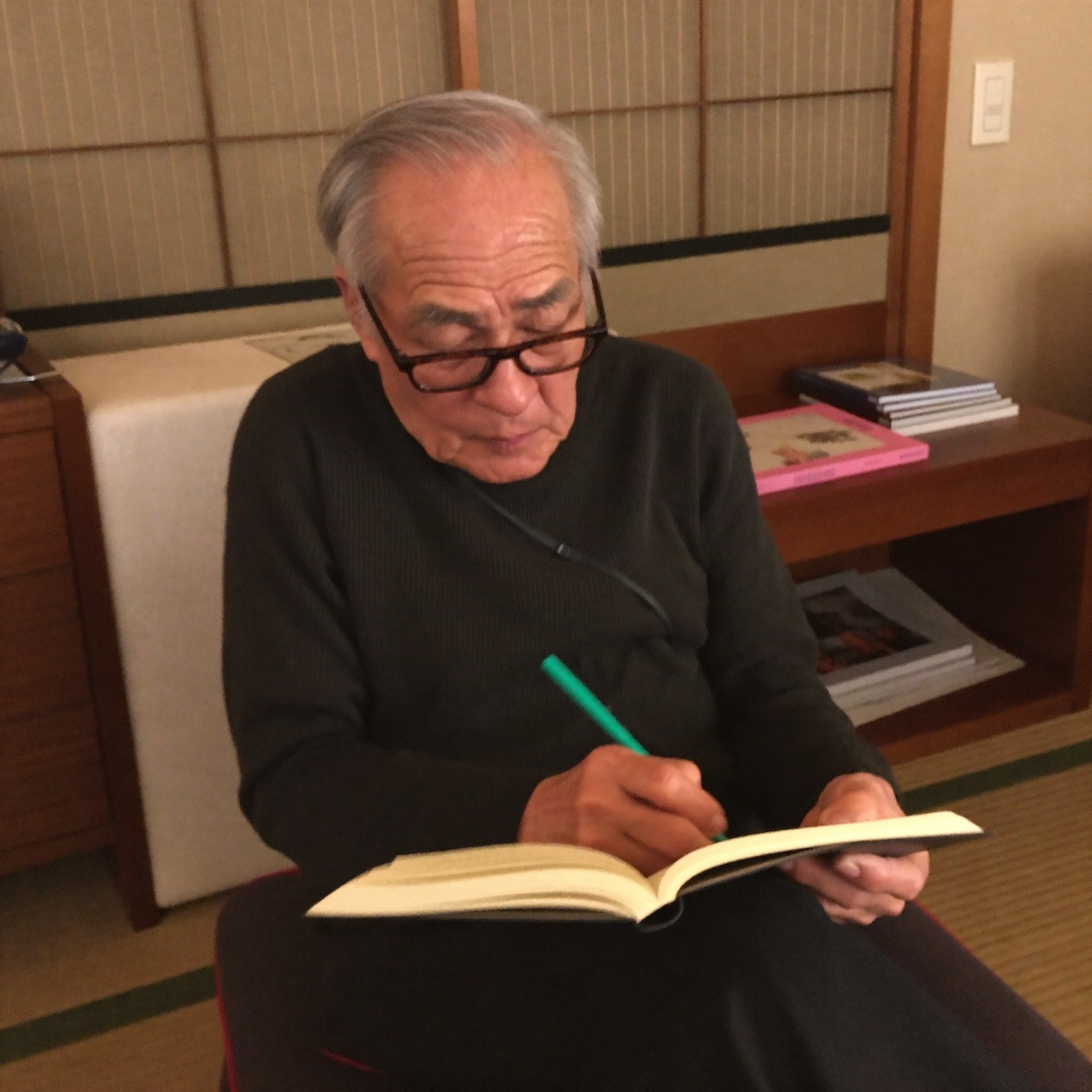 こたつでノートに書き込むお父さん